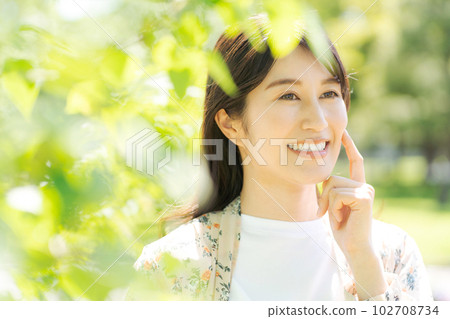 Beauty photo of a woman smiling in the fresh green 102708734