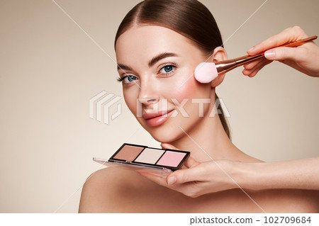 Makeup artist applies eye shadow Makeup artist applies eye shadow 102709684