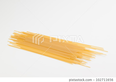 Spaghetti spread out on a white surface. 102711656