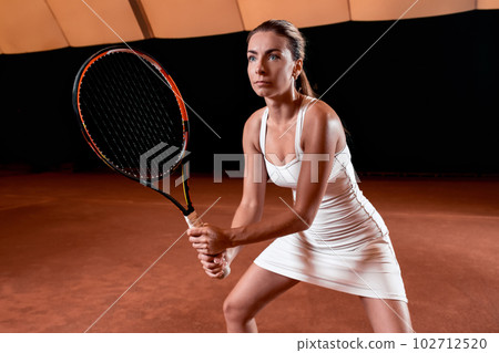 Sportswoman at the tennis court with racquet. 102712520