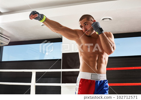 Boxer in blue gloves warming up in the gym Boxer in blue gloves warming up in the gym 102712571