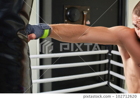 Young boxer training his skills hitting a punching bag. 102712620