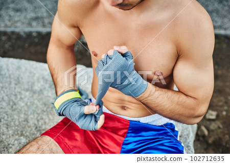 Close up of fit man wearing bandage on his hand Close up of fit man wearing bandage on his hand 102712635