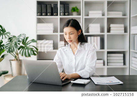 Asian businesswoman working in the modern office with working notepad, tablet and laptop documents Asian businesswoman working in the modern office with working notepad, tablet and laptop documents 102715158