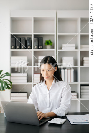 Asian businesswoman working in the modern office with working notepad, tablet and laptop documents Asian businesswoman working in the modern office with working notepad, tablet and laptop documents 102715159