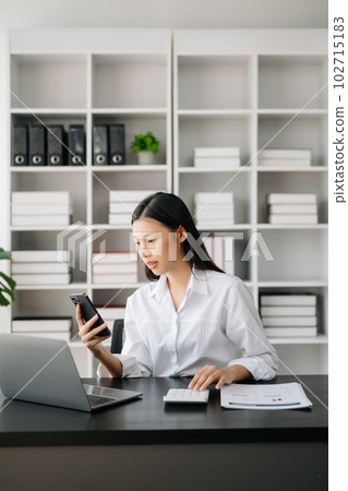 Asian businesswoman working in the modern office with working notepad, tablet and laptop documents Asian businesswoman working in the modern office with working notepad, tablet and laptop documents 102715183