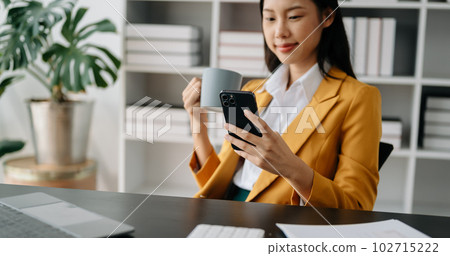 Asian Businesswoman using mobile phone, tablet.Closeup on blurred background 102715222