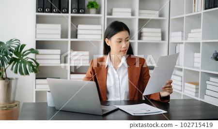 Business woman using tablet and laptop for doing math finance on an office desk, tax, report, accounting, statistics, and analytical research concept in office Business woman using tablet and laptop for doing math finance on an office desk, tax, report, accounting, statistics, and analytical research concept in office 102715419