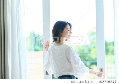 woman standing on balcony woman standing on balcony 102716251