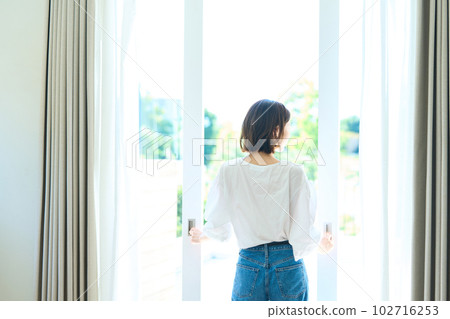 woman standing on balcony woman standing on balcony 102716253