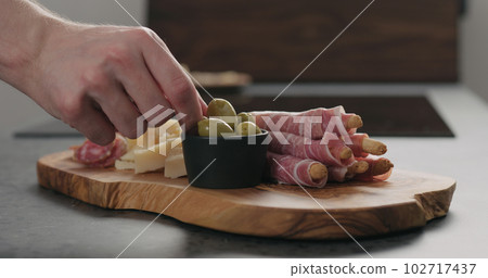 man hand take deli meals from olive wood board man hand take deli meals from olive wood board 102717437