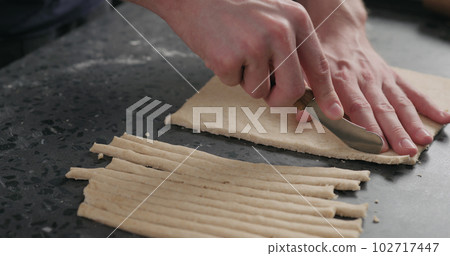 man cutting flat dough with knife 102717447