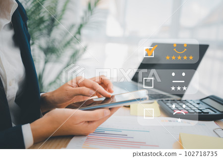 Businesswoman gives ratings to service experience on a smartphone, Service Provider Satisfaction Ratings and Evaluations,  Satisfaction concept and Customer services 102718735