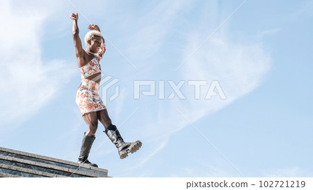 Happy black non-binary person dancing on street and enjoying freedom 102721219