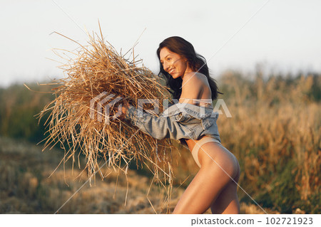 Woman in a summer field. Brunette in a brown underwear. Girl on a sunset background. 102721923