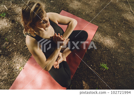 Pretty lady training in a summer park. Brunette doing yoga. Girl in a sportsuit. 102721994