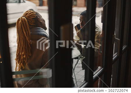Two young people sitting outside. African couple enjoying the time spending with each other. Two young people sitting outside. African couple enjoying the time spending with each other. 102722074