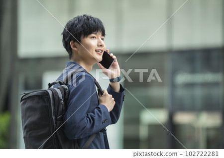 A young man talking on a smartphone 102722281