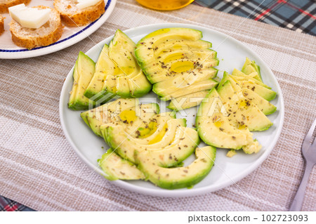 ripe avocado pulp cut into pieces sprinkled with lemon juice on a plate 102723093