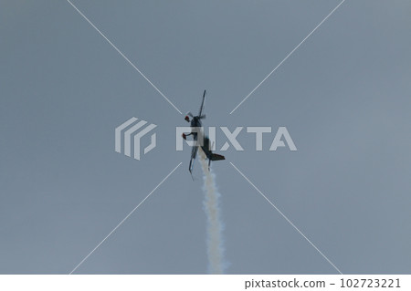 An airplane flying while exhaling smoke 102723221