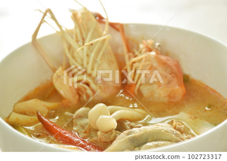 boiled river shrimp with chicken in Thai spicy herb soup or tom yum kung on bowl boiled river shrimp with chicken in Thai spicy herb soup or tom yum kung on bowl 102723317