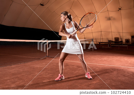 Sportswoman at the tennis court with racquet. 102724410