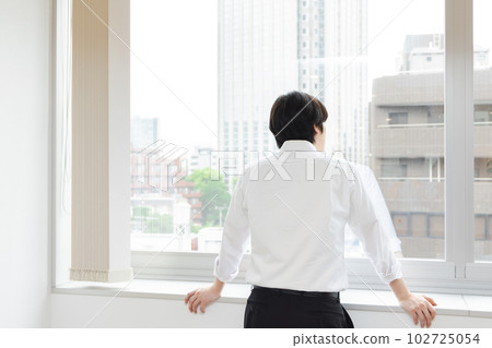 businessman looking out of office businessman looking out of office 102725054