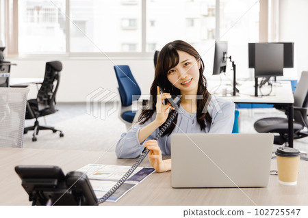 Business woman talking on a fixed phone (extension) Business woman talking on a fixed phone (extension) 102725547