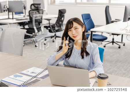 Business woman talking on a fixed phone (extension) Business woman talking on a fixed phone (extension) 102725548