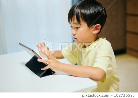 Elementary school boy watching videos on tablet 102726553