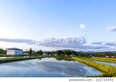 Photo Filling water in preparation for rice planting Preparing for rice planting in a rice field that looks like a water mirror 102729343