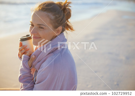 happy modern woman in cosy sweater at beach in evening happy modern woman in cosy sweater at beach in evening 102729952