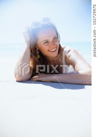 happy stylish 40 years old woman laying at beach 102729978