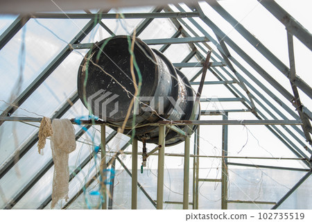The water tank in the greenhouse is used to water the plants. The water tank in the greenhouse is used to water the plants. 102735519