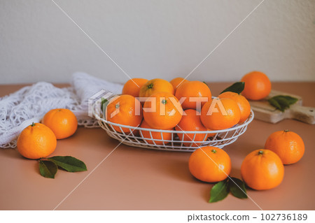 Harvesting oranges, or mandarin with green leaves . The vitamin C and nutrition of orange. 102736189