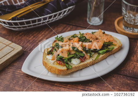smoked salmon toast with sourdough and cheese. healthy mediterranean eating and diet. smoked salmon toast with sourdough and cheese. healthy mediterranean eating and diet. 102736192
