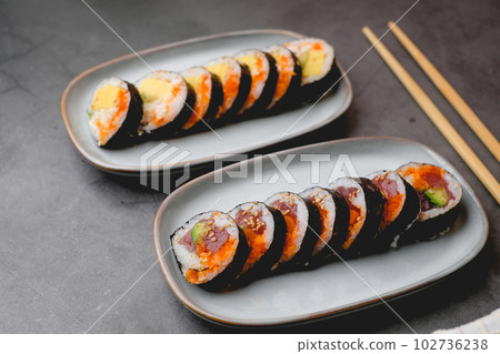 Close up spicy tuna sushi roll on the stone table top. Japanese food and sushi concept. 102736238