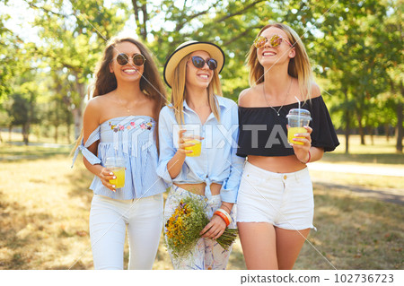 Three nice girls having fun In the park and make selfie. Excellent sunny weather. Beautiful figures. Three nice girls having fun In the park and make selfie. Excellent sunny weather. Beautiful figures. 102736723