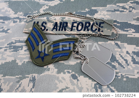 August 31, 2020. US AIR FORCE branch tape and Senior Airman rank patch and dog tags on digital tiger-stripe pattern Airman Battle Uniform (ABU) August 31, 2020. US AIR FORCE branch tape and Senior Airman rank patch and dog tags on digital tiger-stripe pattern Airman Battle Uniform (ABU) 102738224