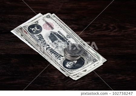 Old US banknotes and silver certificates with silver dollar coins 102738247