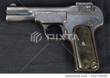 Old rusty handgun on black canvas 102738300