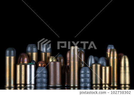 Ammuninition isolated on black background with reflexion. Different cartridges for rifle, pistols and revolvers on a black. Ammuninition isolated on black background with reflexion. Different cartridges for rifle, pistols and revolvers on a black. 102738302