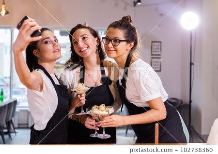 Fenale students in cookery class taking selfie after cooking - friends and social media concept Fenale students in cookery class taking selfie after cooking - friends and social media concept 102738360