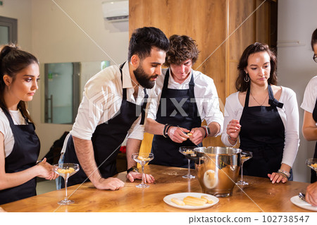 Chef teaching trainees how to make ice cream. Cooking tasty ice cream dessert made from chocolate and vanilla in glass bowl 102738547
