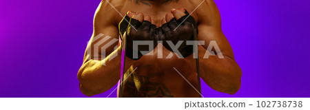 Sporty man performs exercises with expander on studio background. Strength and motivation 102738738