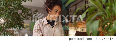 Successful female florist working online from own floral studio and check customers order Successful female florist working online from own floral studio and check customers order 102738816