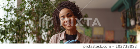 Portrait of smiling woman florist presenting beautiful floral composition with succulent plant 102738858