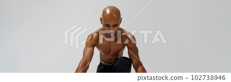 Sportsman with naked torso is warming up before workout on white studio background Sportsman with naked torso is warming up before workout on white studio background 102738946