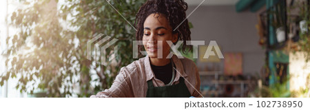 Professional woman florist making succulent plant composition at floral design studio Professional woman florist making succulent plant composition at floral design studio 102738950