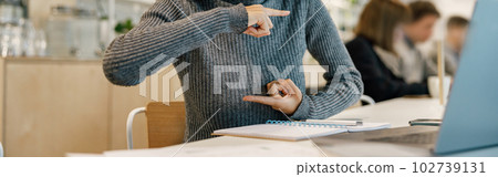 Smiling african woman speaks sign language with friends by video call while sitting in cozy cafe Smiling african woman speaks sign language with friends by video call while sitting in cozy cafe 102739131